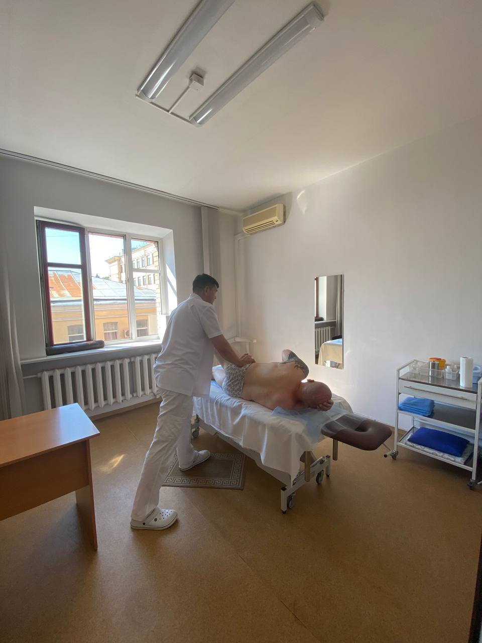 Практикующий мануальный терапевт работает с пациентом