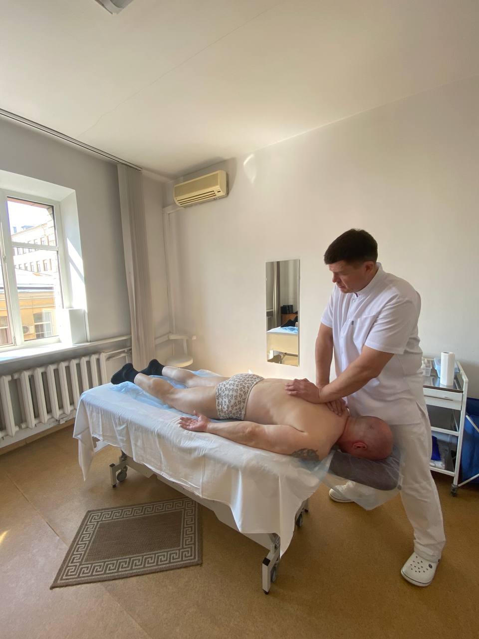 Фотография мануального терапевта, который проводит процедуру массажа для лечения грыжи диска